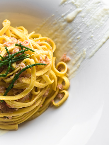# ulisse albiati food photographer: Italian cuisine specialty: fettuccine made of fresh pasta with crab, salicornia and sweet garlic cream. Le Pavoniere restaurant in Florence, Tuscany.