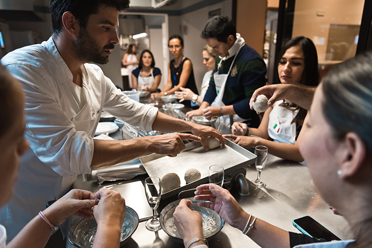 # ulisse albiati food photographer: a master chef teaches the secret of a special and delicious pizza during a cooking workshop. Cooking school in Florence, Tuscany.