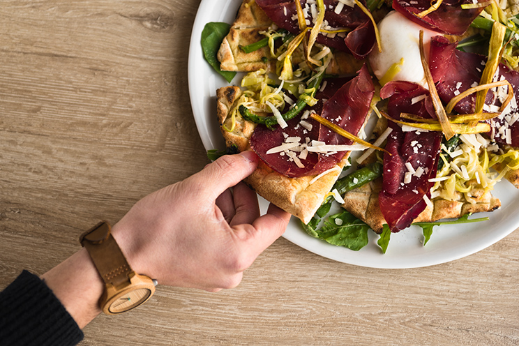 # ulisse albiati food photographer: taking a slice of a special pizza with fresh mozzarella, aged Parmigiano, dry cured ham and various vegetables as complete meal. Le Pavoniere restaurant in Florence, Tuscany.