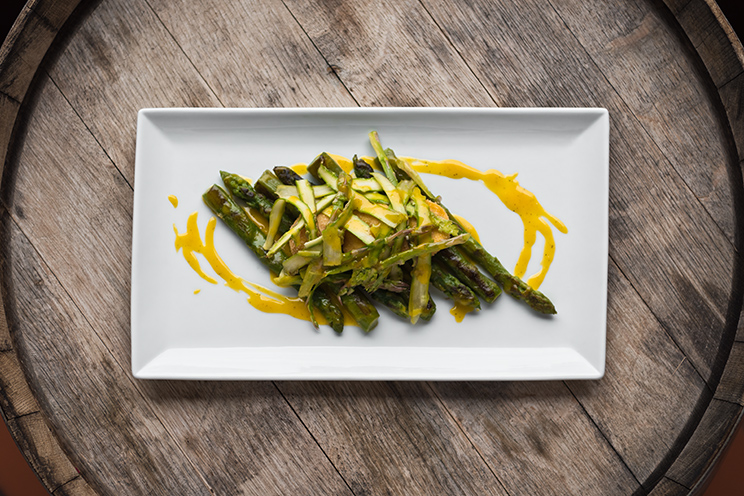 # ulisse albiati food photographer: a bundle of cooked asparagus with filanger, fried egg yolk and carbonara sauce as second course. Le Pavoniere restaurant in Florence, Tuscany.