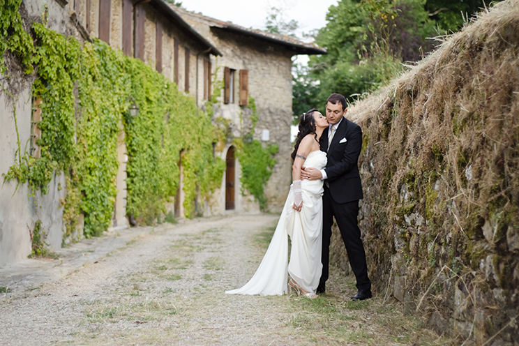 # The bride kisses the groom. The old house of Gabriele D'Annunzio in the background (Castello di Romena, Casentino, Tuscany).